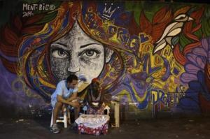 A woman reads cards to predict the future of a customer along a street in Rio de Janeiro, March 18, 2014. REUTERS/Nacho Doce