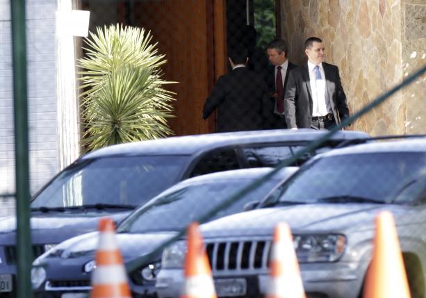 Federal police officers walk in front of the entrance of the home of Lower House Speaker Cunha in Brasilia